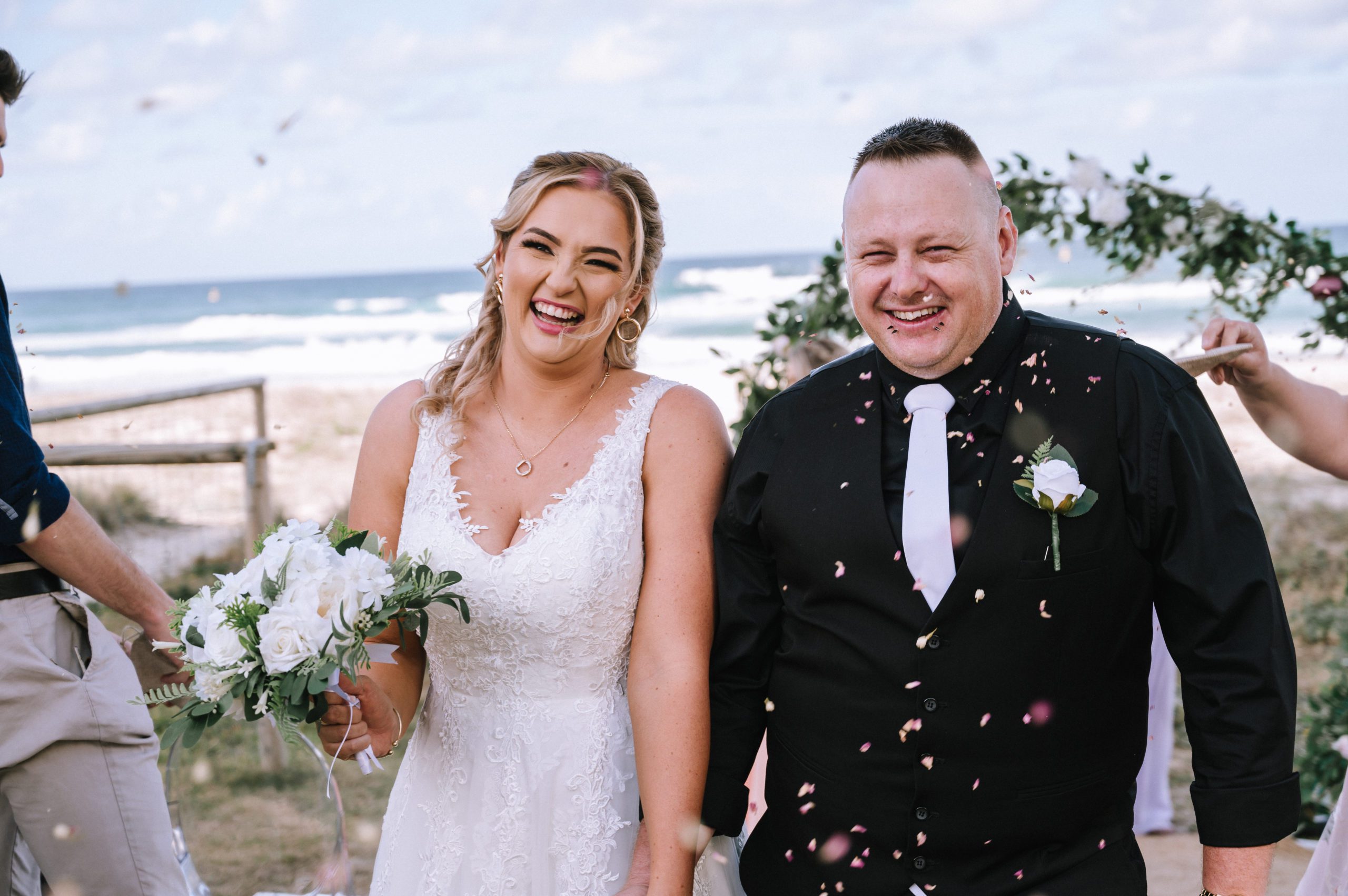 Beach wedding with confetti being thrown over the couple