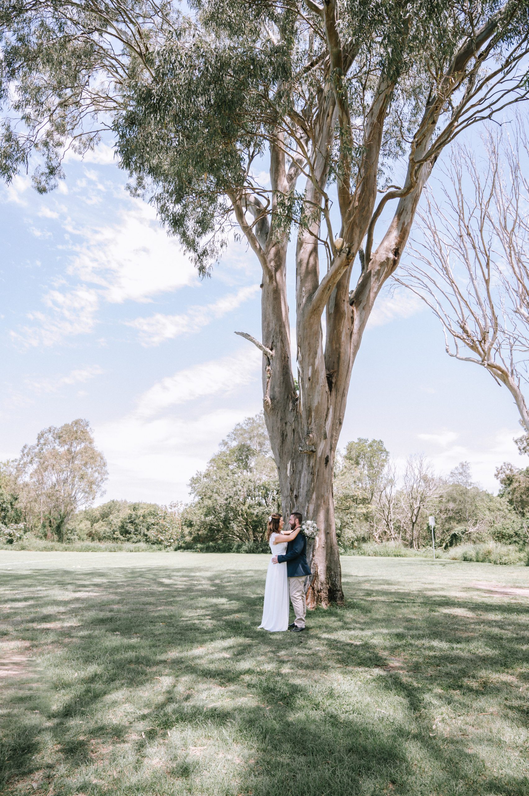 Gayle & Craig standing in front of a tree with their arms around each other after just getting married