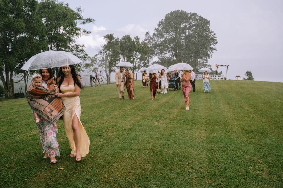 guests walking in the rain after elopement at lakehouse folk