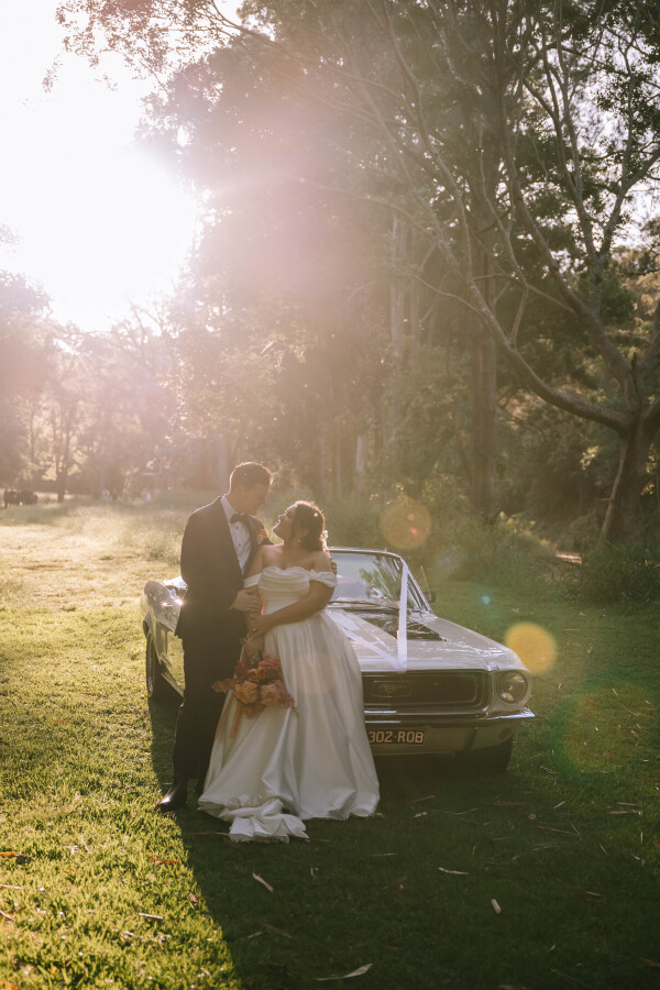 couples wedding portraits next to vintage car at Bundaleer Rainforest Gardens