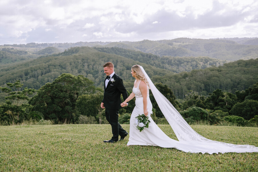 Couple walking hand in hand across Lakehouse Folk’s private grounds