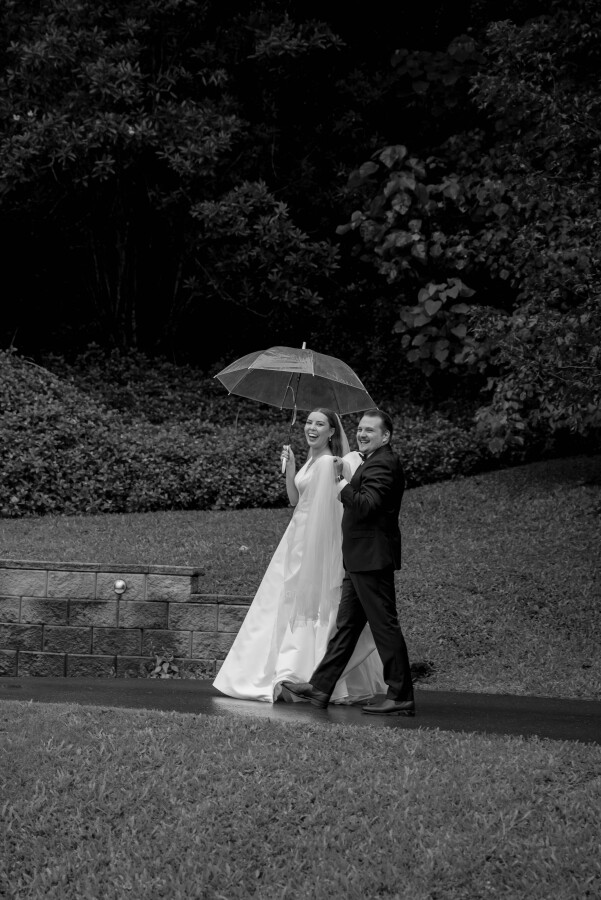 couple walking in the rain after maleny manor wedding ceremony