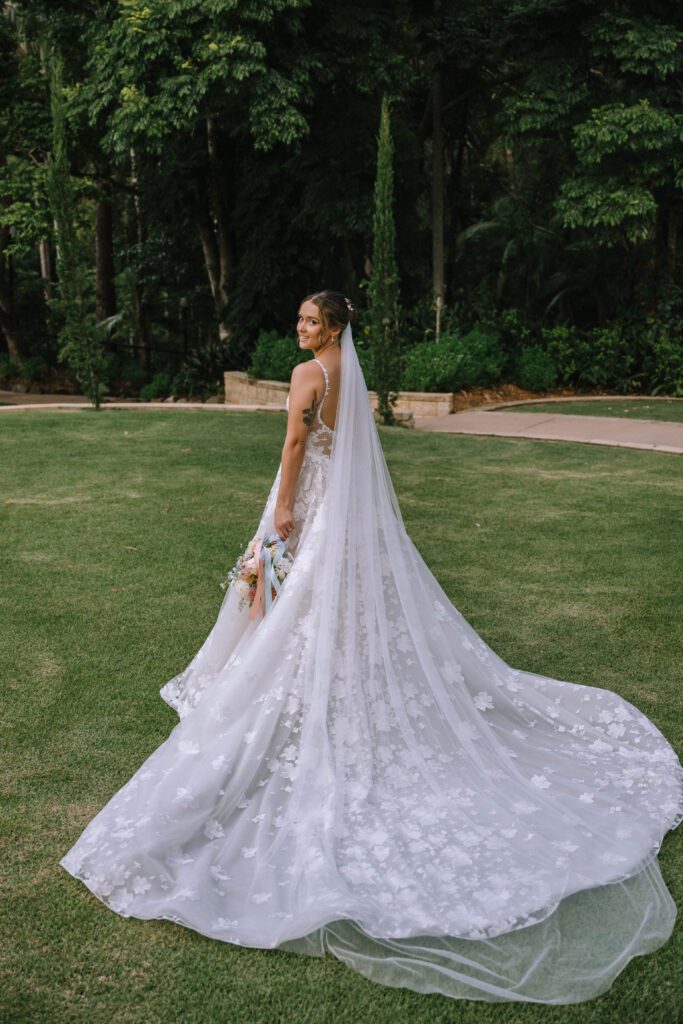 portrait of bride's stunning wedding veil from behind amongst the sunshine coast hinterland greenery