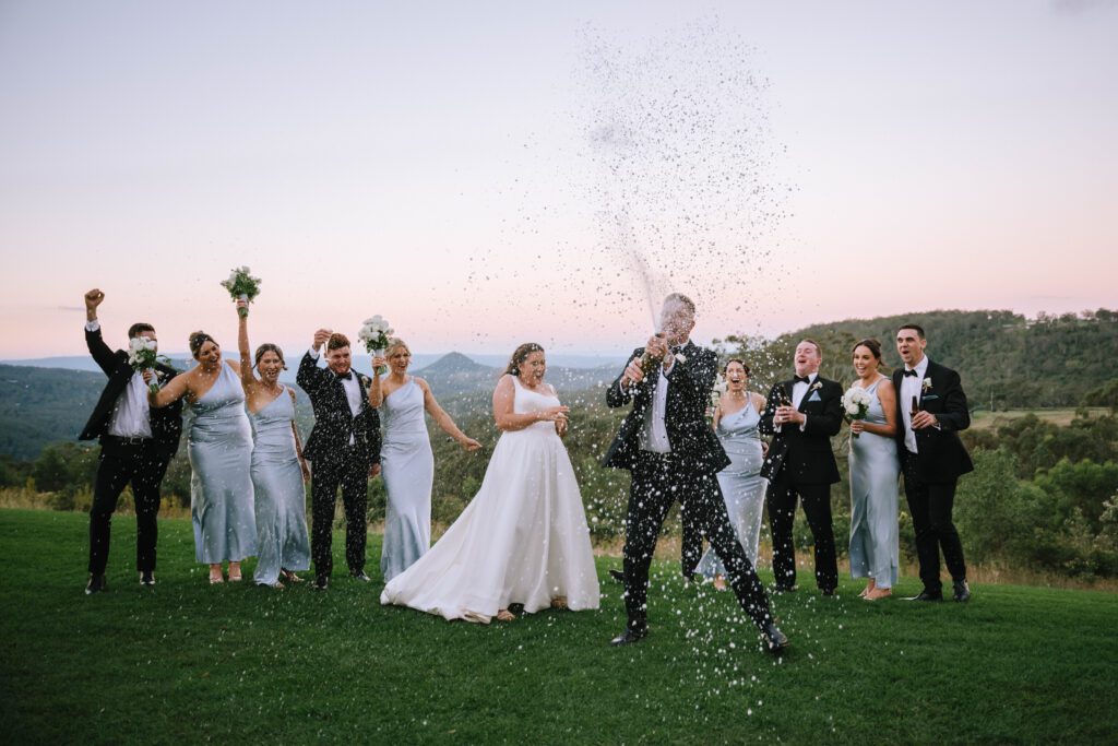groom champagne spray during wedding party portraits after sunshine coast wedding ceremony