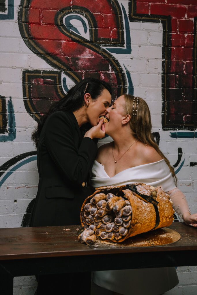 couple sharing a cannoli during sunshine coast wedding celebration