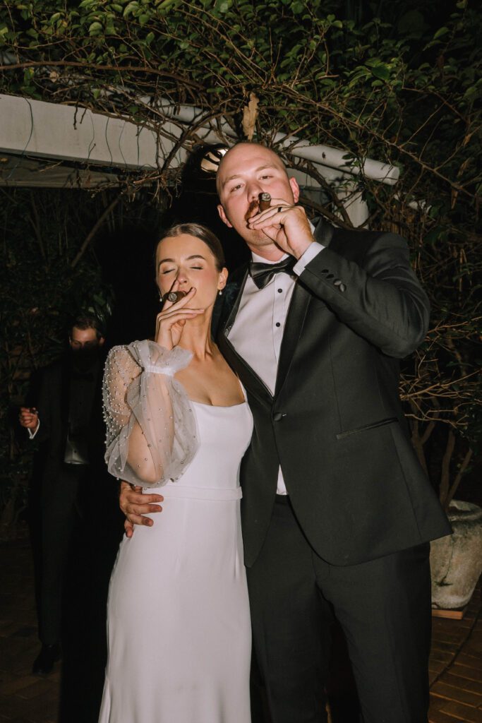 couple smoking cigars during sunshine coast wedding reception
