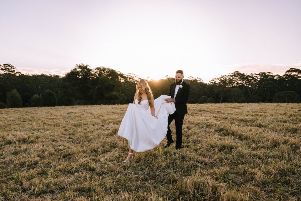 portrait of bride and groom walking through field in sunshine coast hinterland