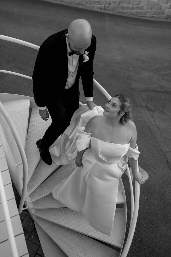 black and white editorial portrait of bride and groom walking down stairs at Maleny Manor in the sunshine coast hinterland