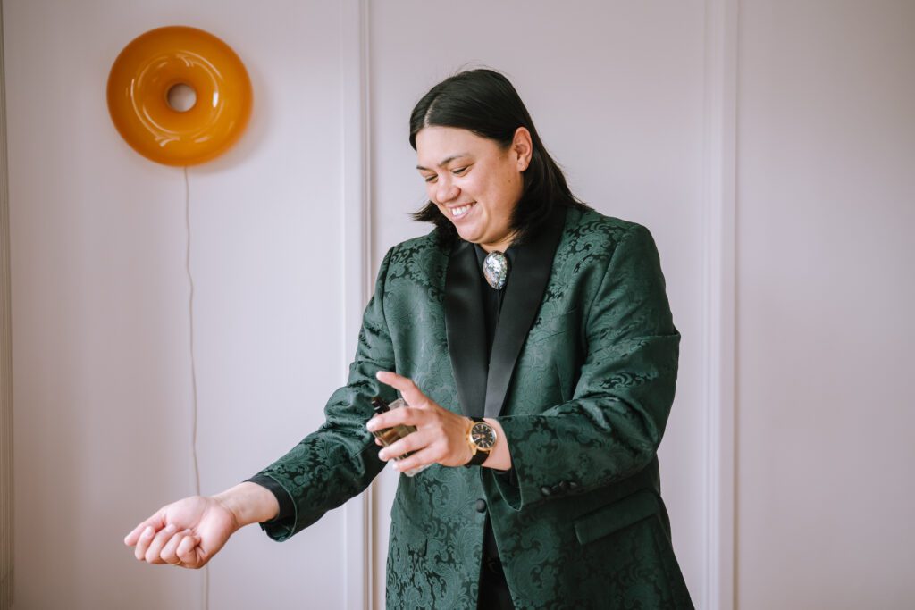 bride spraying perfume while getting ready in hotel room at emporium hotel southbank