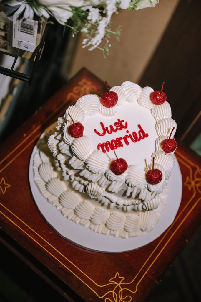 cute just married heart shaped wedding cake with icing and candied cherries