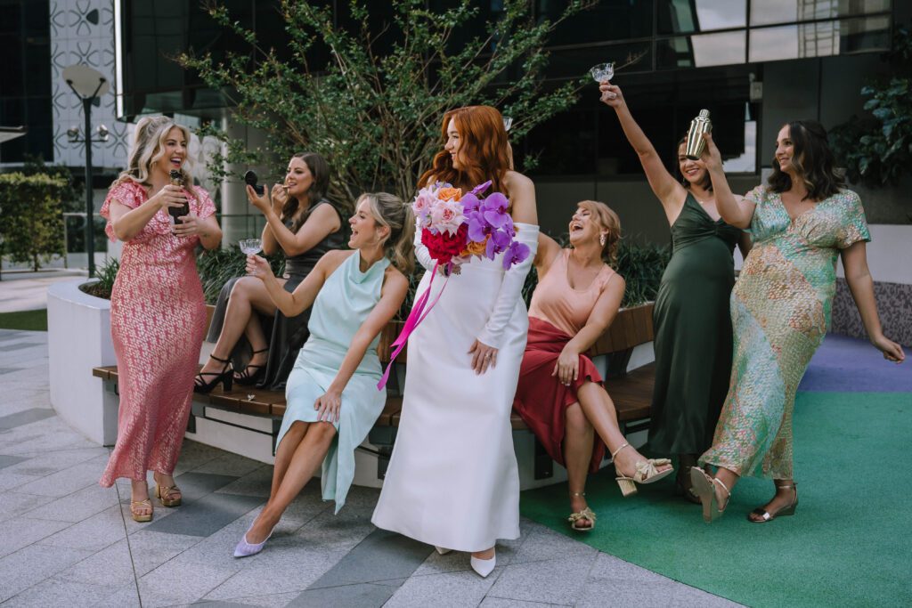 candid shot of bride with her bridal party standing outside w brisbane hotel 