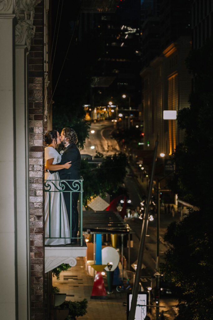 editorial shot of couple kissing on the balcony at Tattersall’s Club in brisbane cbd