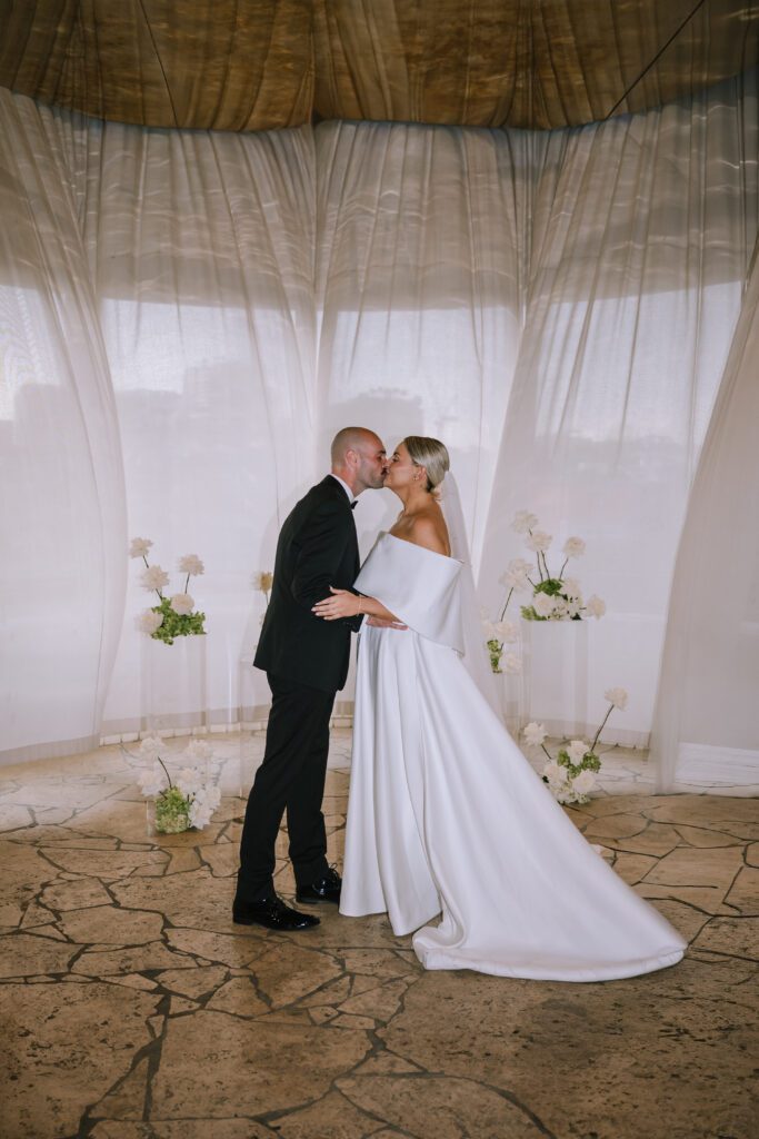 couple kissing during indoor wedding ceremony at the calile hotel in brisbane