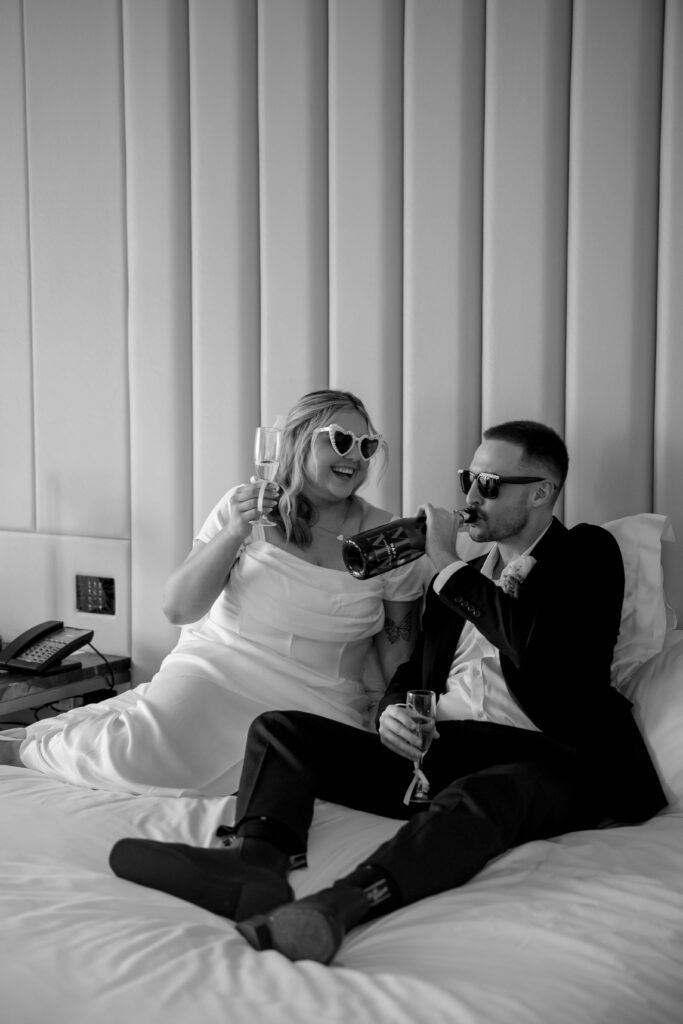 couple drinking champagne on the bed in hotel room at Emporium Hotel South Bank