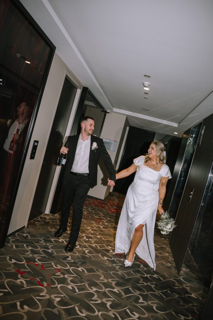 couple walking down hallway hand in hand after ceremony at Emporium Hotel South Bank