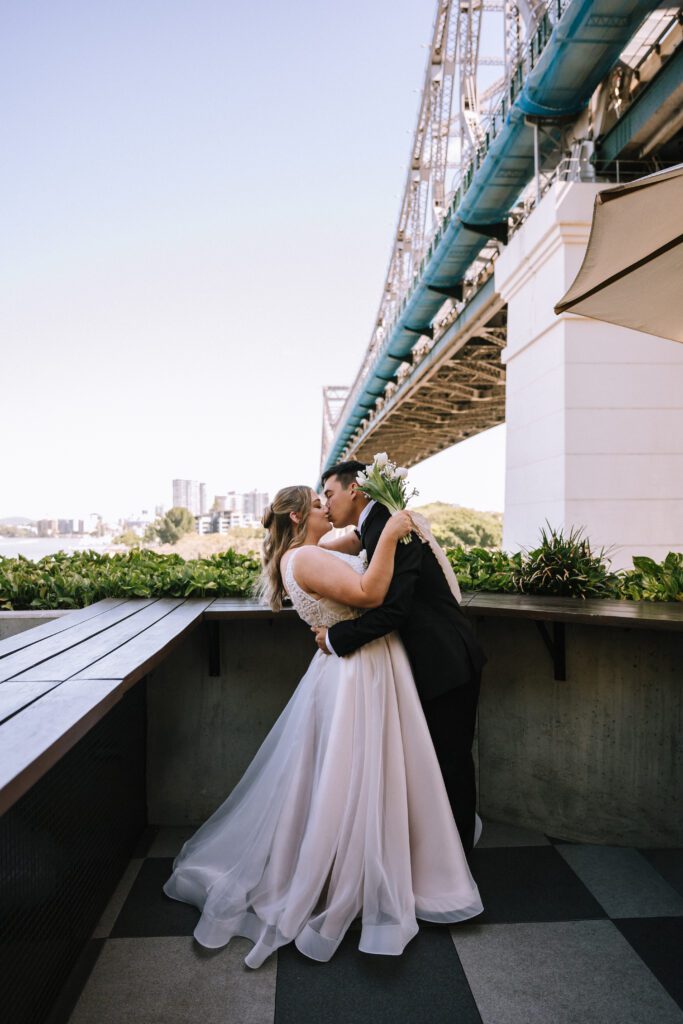 couple kissing on outdoor deck at Crystalbrook Vincent hotel wedding venue in brisbane cbd
