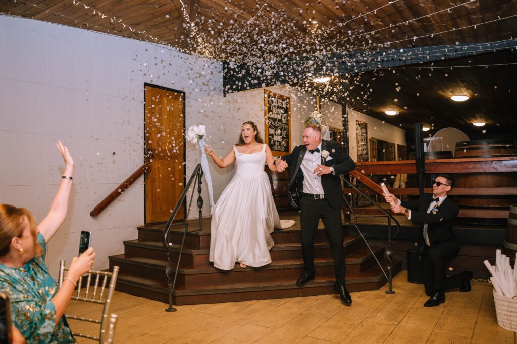 candid shot of confetti explosion for couple's arrival at wedding reception 