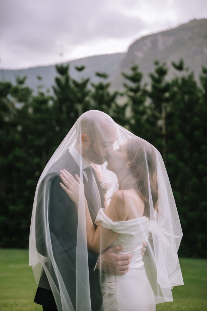 couple kissing under bride's veil digital editorial style portrait