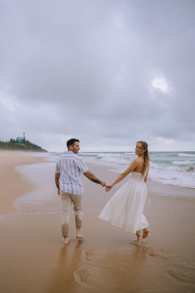 couple walking on beach during engagement shoot digital photograph example