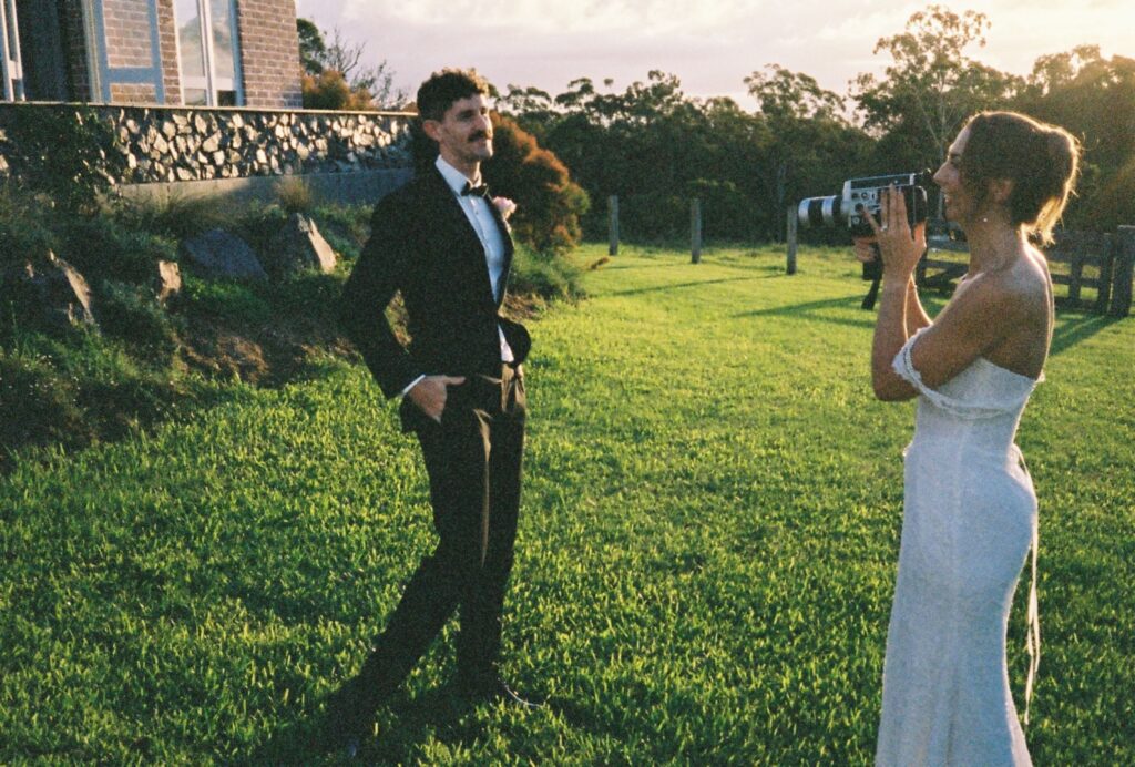bride taking photo of groom using 35mm film camera