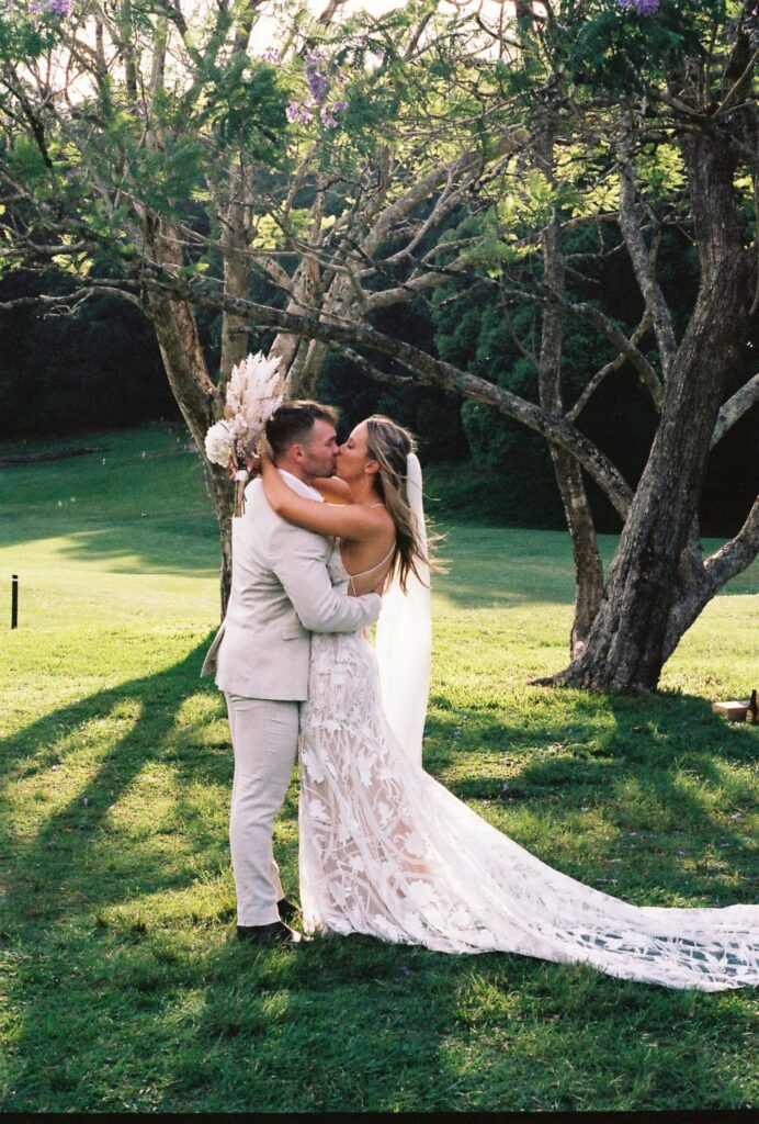 bride and groom kissing after outdoor ceremony 35mm film photograph