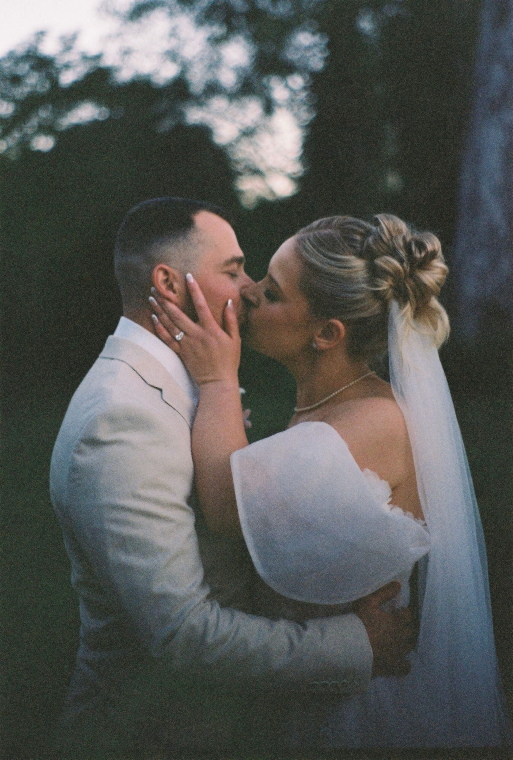 35mm film wedding photography of couple kissing after ceremony