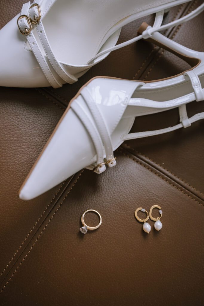 close up of bride's accessories including bridal heels, engagement ring, and earrings