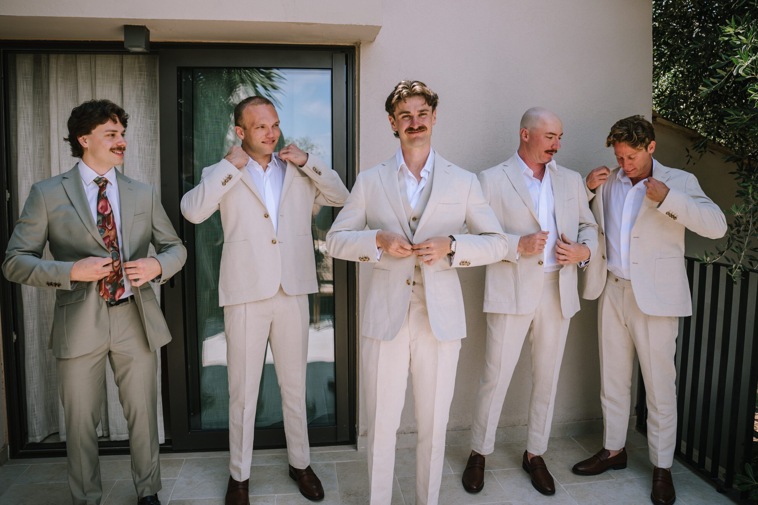 groom and groomsmen adjusting their linen suits at Hyatt Ziva Corfu
