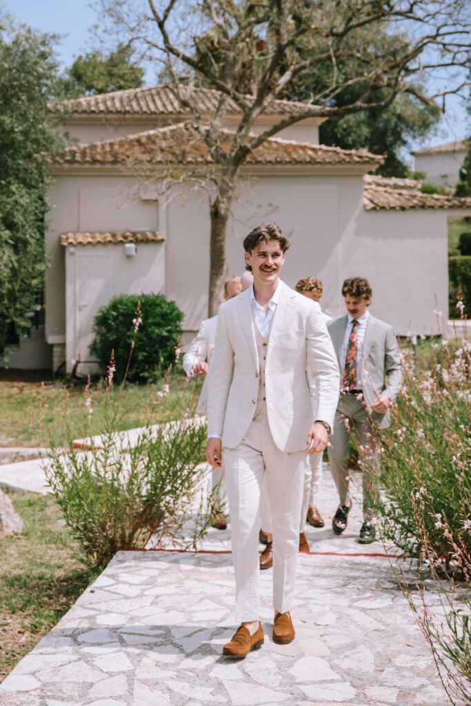 groom and wedding party walking towards wedding ceremony location at Hyatt Ziva Corfu