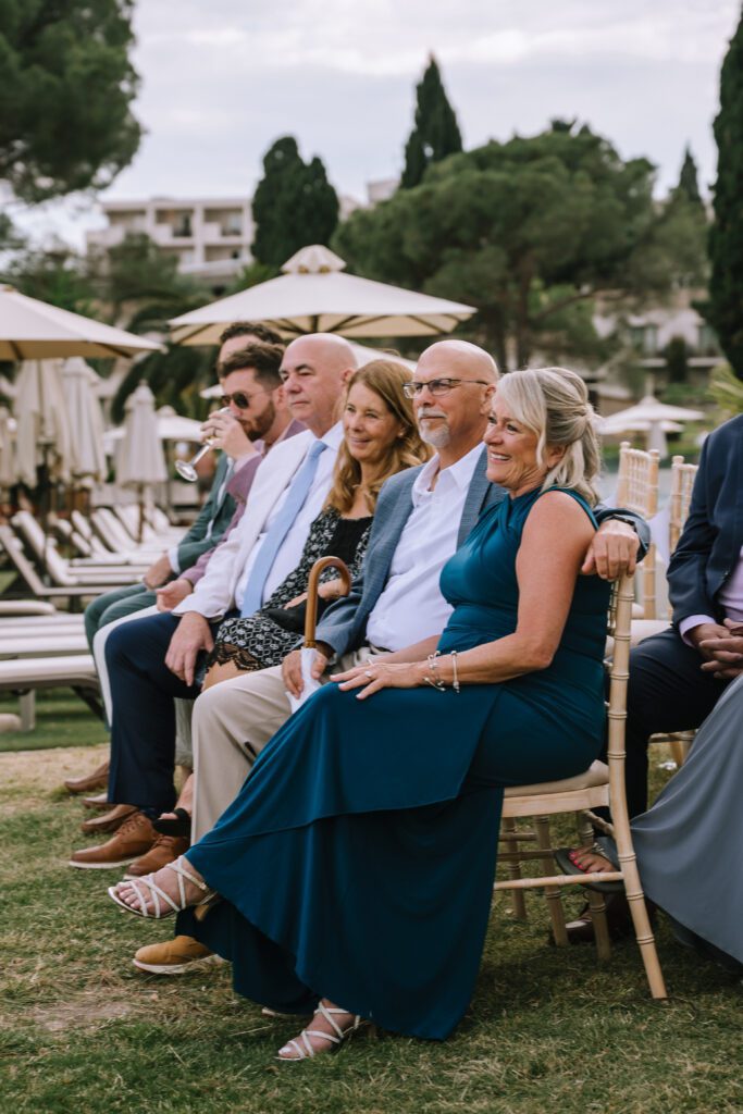 candid portrait of wedding guests smiling during wedding ceremony