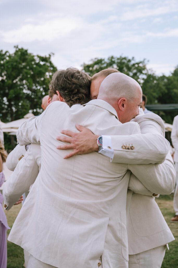 groom hugging his groomsmen after the wedding ceremony