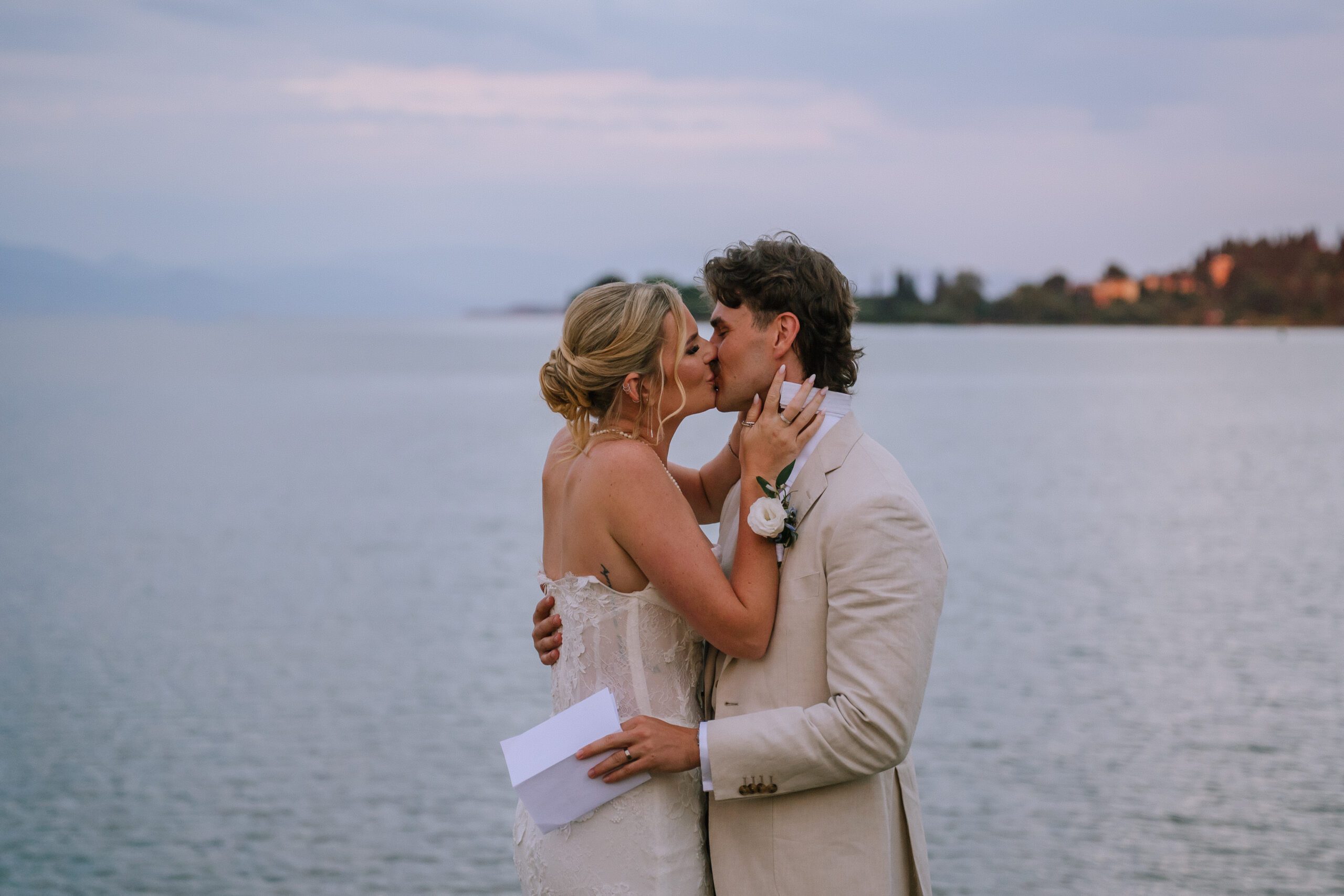 couple embracing for an intimate kiss after reading private letters to each other with gouvia bay in the background