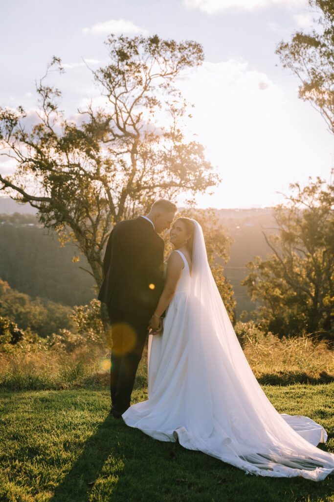 wedding couple holding hands with soft, natural light in the background