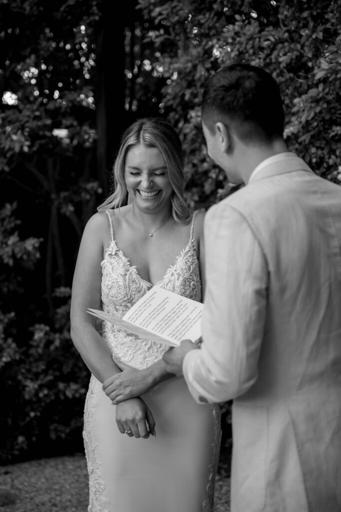 black and white documentary style portrait of groom reading private vows to bride during first look