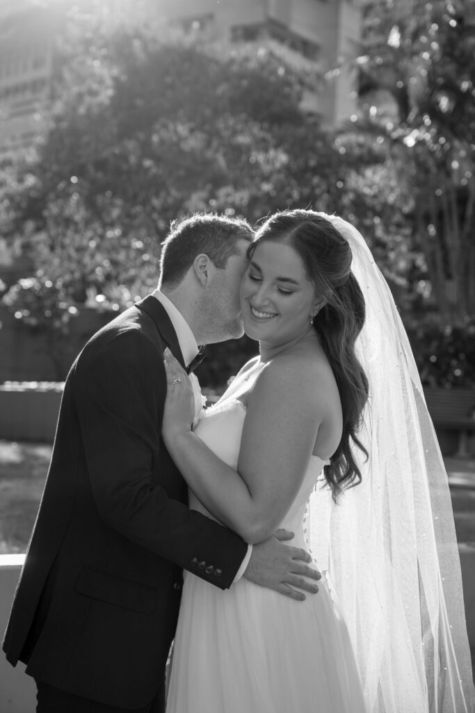 classic timeless black and white portrait of couple embracing with bride turned towards camera